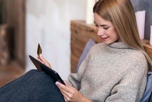 カードとタブレットを操作する女性