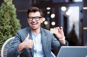 親指を立てて喜びながらゴールドカードを持つ男性