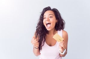 ゴールドカードを持ちながらガッツポーズする女性