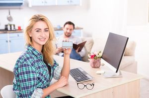 カップルの女性がPCの前でクレジットカードを持つ様子