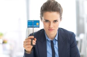 はさみでクレジットカードを切ろうとする女性