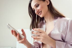 スマホを見ながらお茶する女性