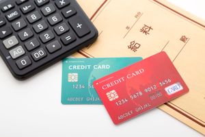給料袋とクレジットカード2枚と電卓