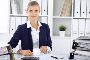 カップを持ちこちらをみるスーツ姿の女性