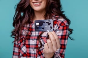 カードを提示するチェック柄のシャツをきた女性