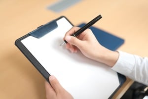 紙に何かを書こうとしている