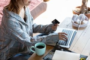 クレジットカードを見ながらPCを操作する女性