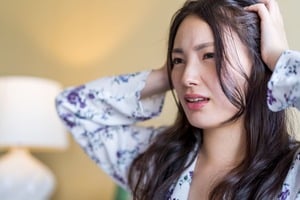 ACマスターカーのデメリットを聞き頭を抱える髪の長い女性
