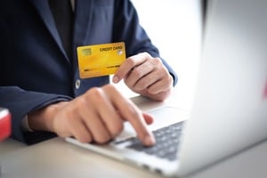 ゴールドカードを持ちながらパソコンを扱う手元