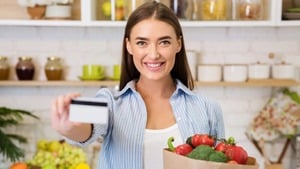 デビッドカードを持ち買い物袋を抱えた女性
