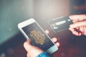 スマホとクレジットカードを持つ手元