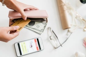 メガネとスマホの上でウォレット殻をクレジットカードを取り出す