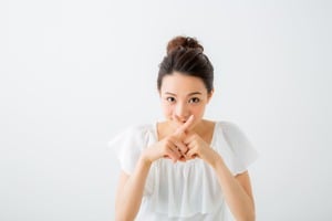 指でクロスする女性