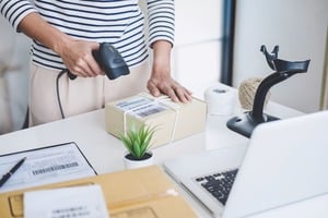 荷物のバーコードにリーダーをあてる女性