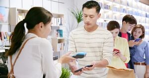 スマホ決済でレジに並ぶ人