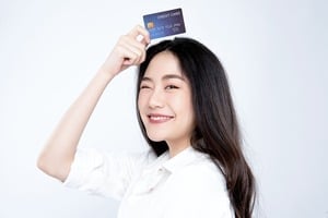 頭にクレジットカードをのせる女性