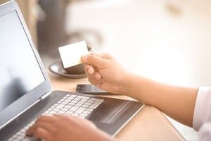 クレジットカードを見ながらパソコンを打つ